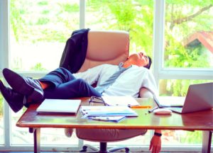 Lazy businessman asleep at his desk