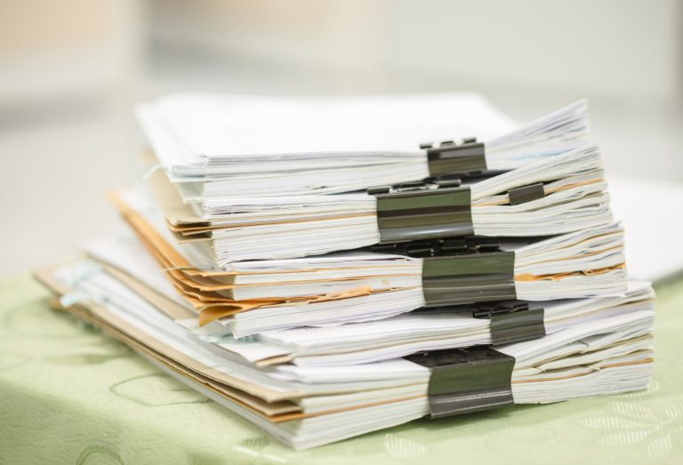 stack of forms with binder clips